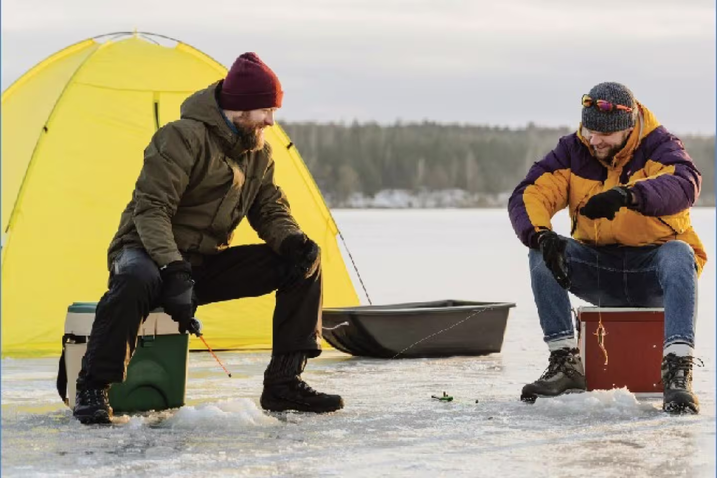 Deux hommes qui font de la pêche sur glace