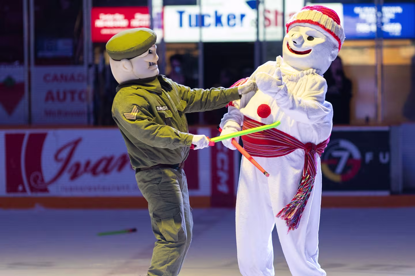 Bonhomme Carnaval qui joue aux épées avec Sarge sur la patinoire.