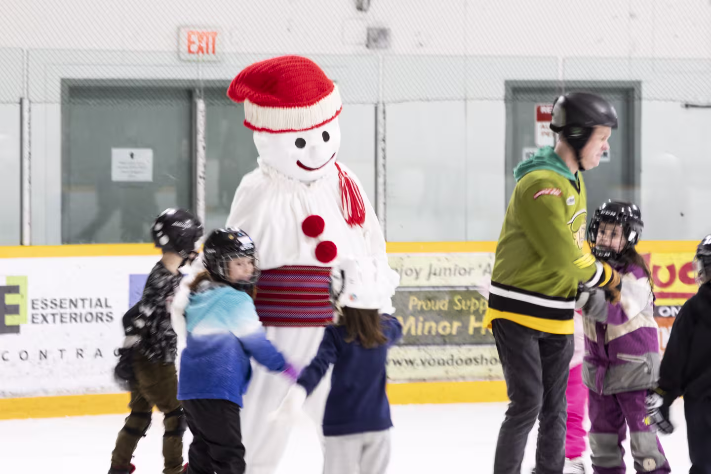 Bonhomme Carnaval entouré d'enfants sur la patinoire