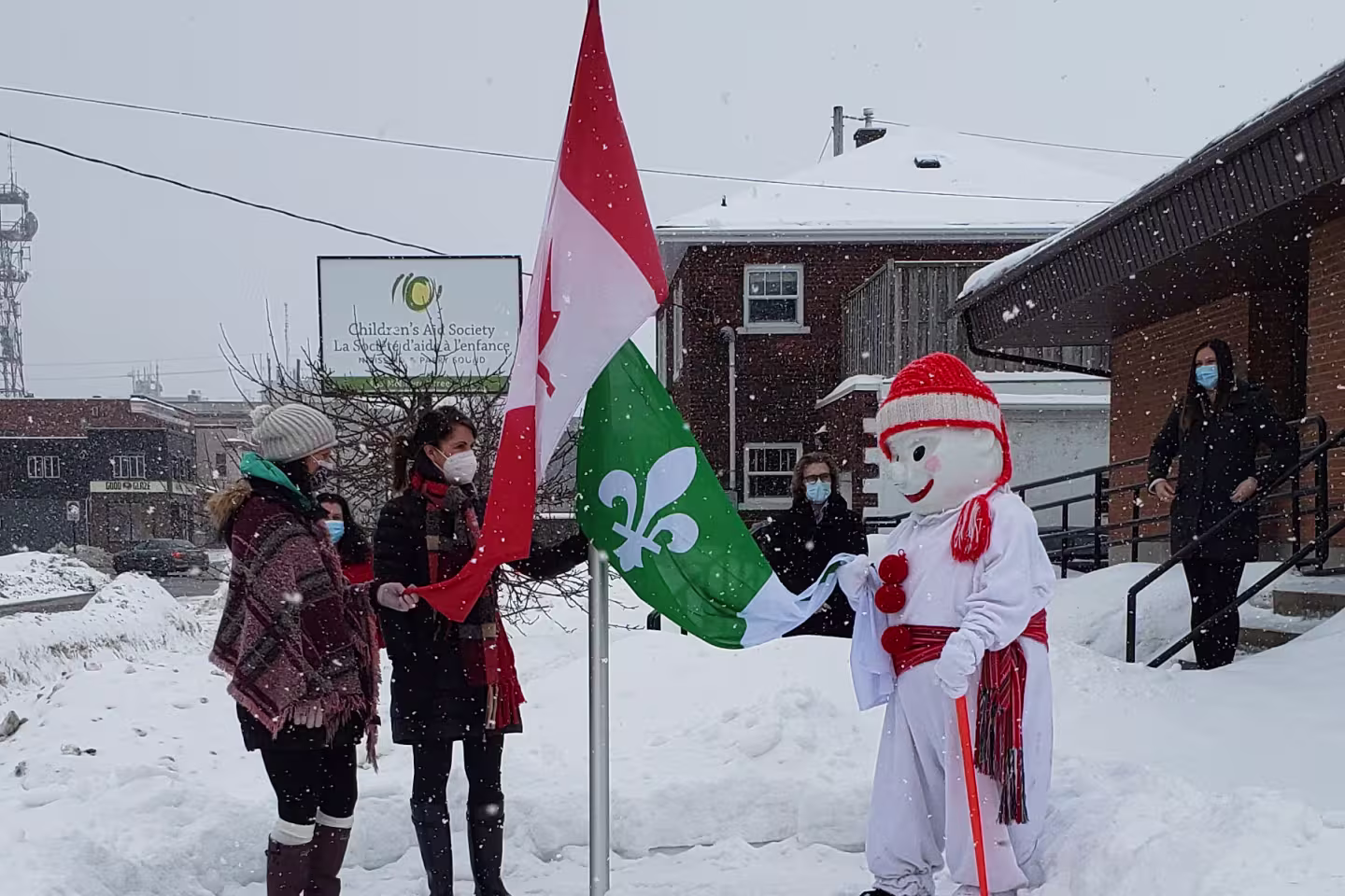Bonhomme Carnaval qui lève le drapeau franco-ontarien