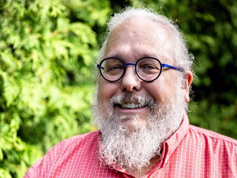 Portrait de Joël Ducharme, devant des arbres.