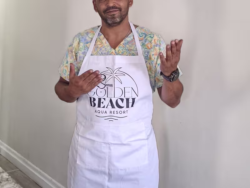 Photo de Reda Fetnassi, avec un chapeau de chef noir et un tablier blanc.