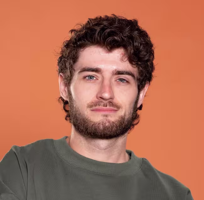 Portrait de Jonathan Dion devant un arrière-plan orange
