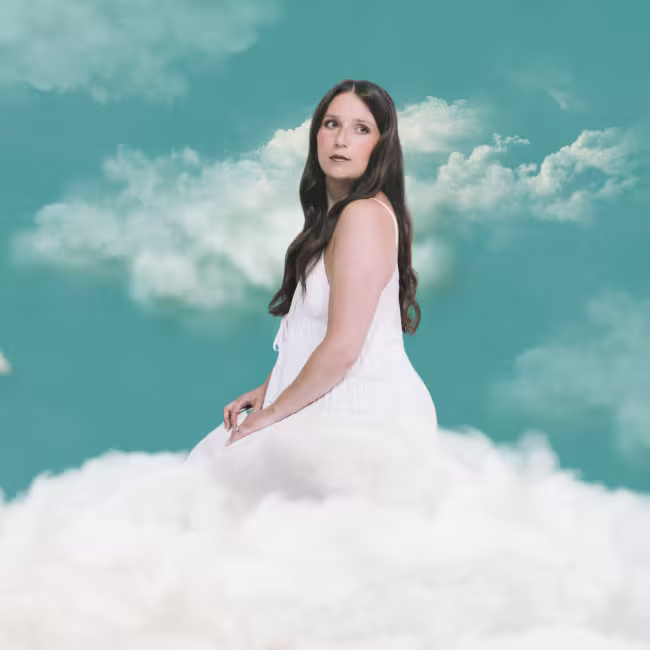 Photo de Céleste Lévis sur un nuage avec un ciel bleu derrière elle.