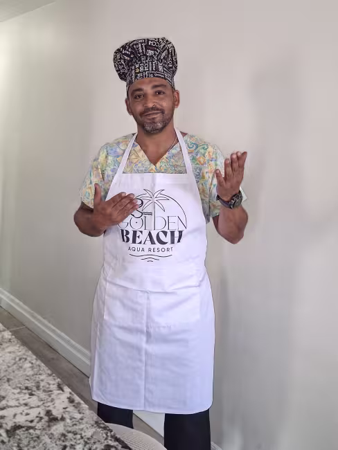 Photo de Reda Fetnassi, avec un chapeau de chef noir et un tablier blanc.